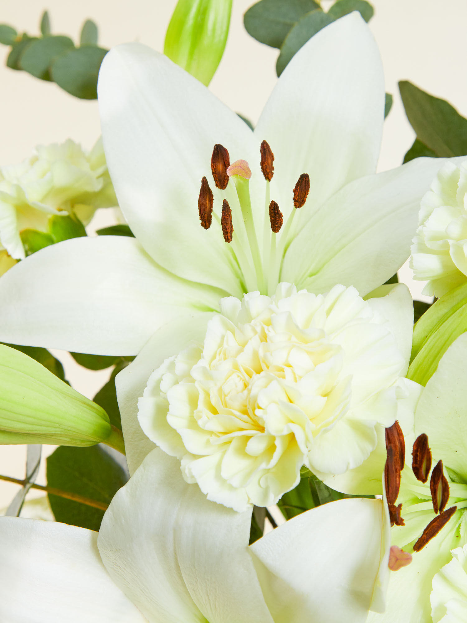 Ich denk an Dich Nahaufnahme von weißen Nelken und Lilien und grünem Eukalyptus