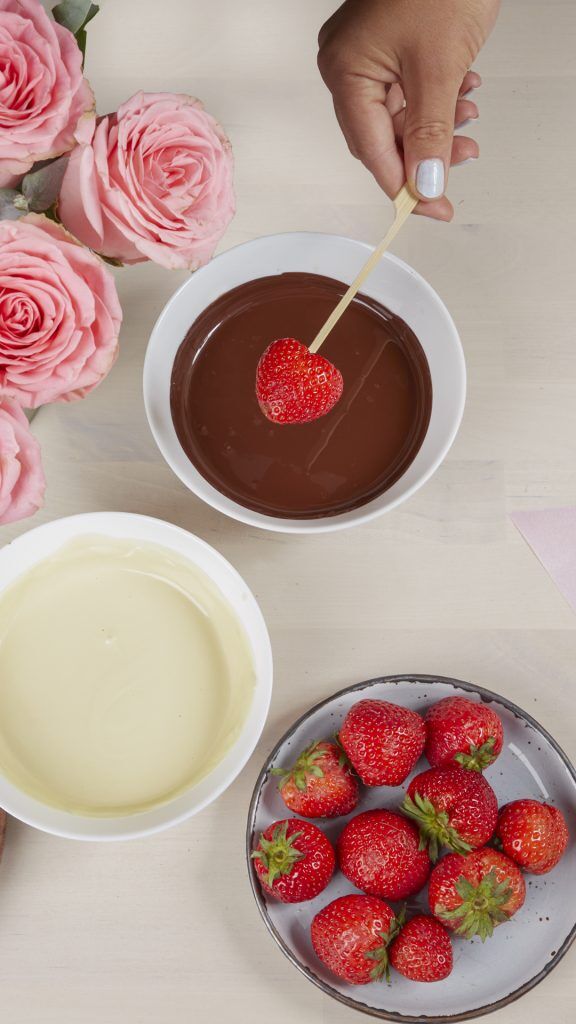 Erdbeeren in Konfitüre tauchen