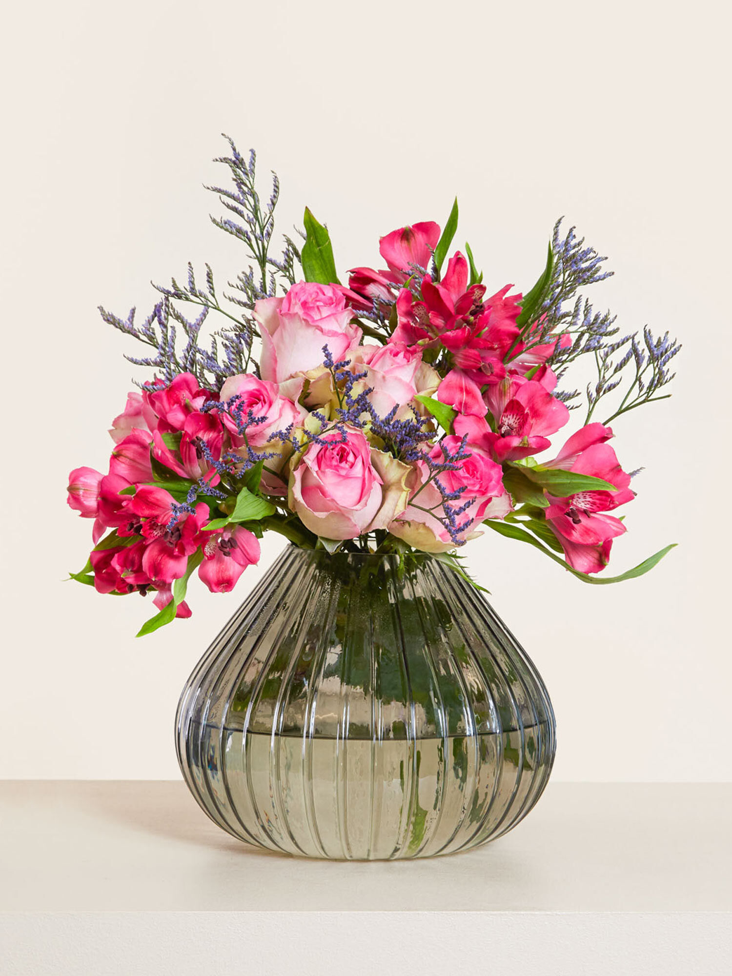 Nur für Dich Eine Kombination aus Violetten, Rosa und Roten Rosen, Alstromerien und Limonium arrangiert in einer Tischvase
