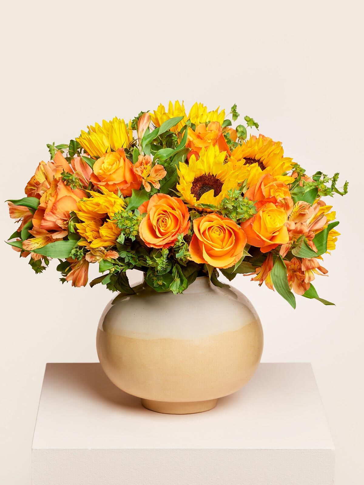 Sunny Gelbe und orangene  Fairtrade Sonnenblumen, Rosen, Alstromerien, Hasenohren arrangiert in einer  beigen Keramikvase
